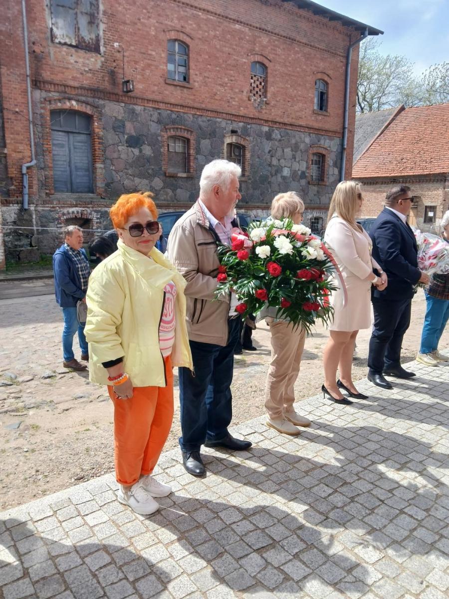 Delegacja z Dębna stoi z kwiatami 