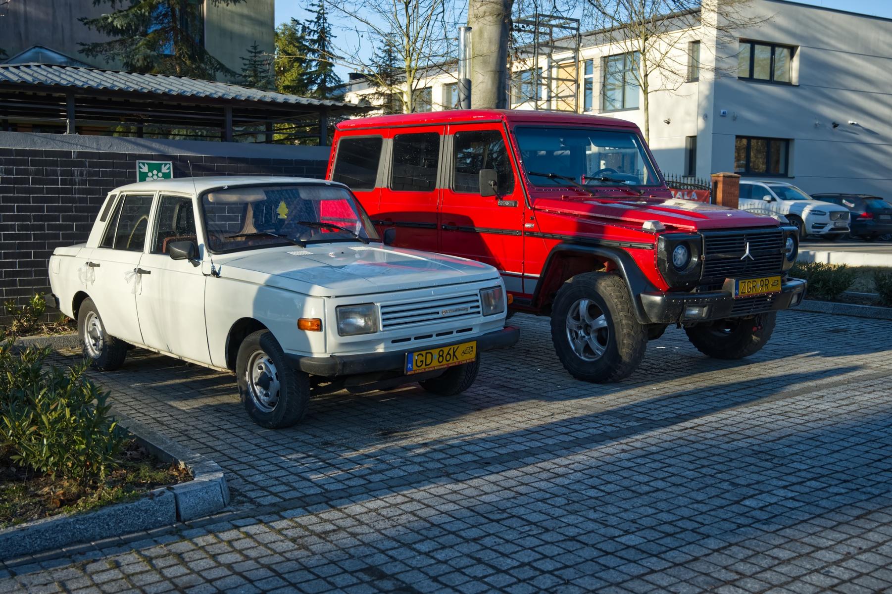 Dwa samochody z czas&oacute;w PRL stoją na parkingu