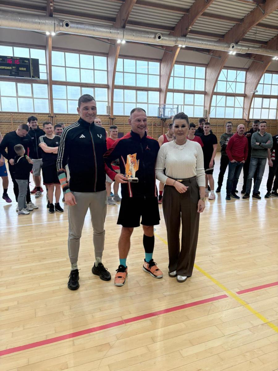 Od lewej na hali stoją: mężczyzna, mężczyna z pucharem, kobieta - dyrektor OSiR-u