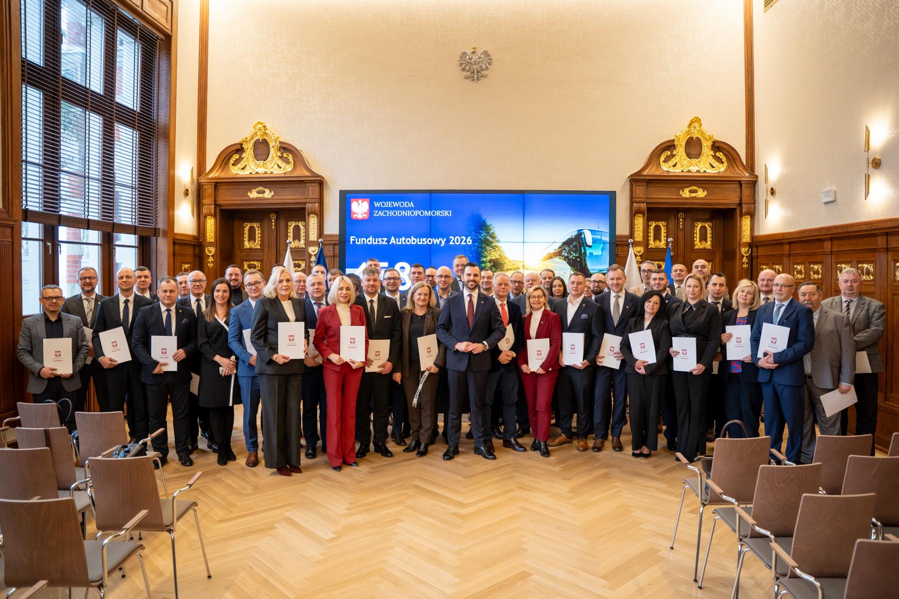Kilkadziesiąt os&oacute;b stoi w eleganckim wnętrzu 