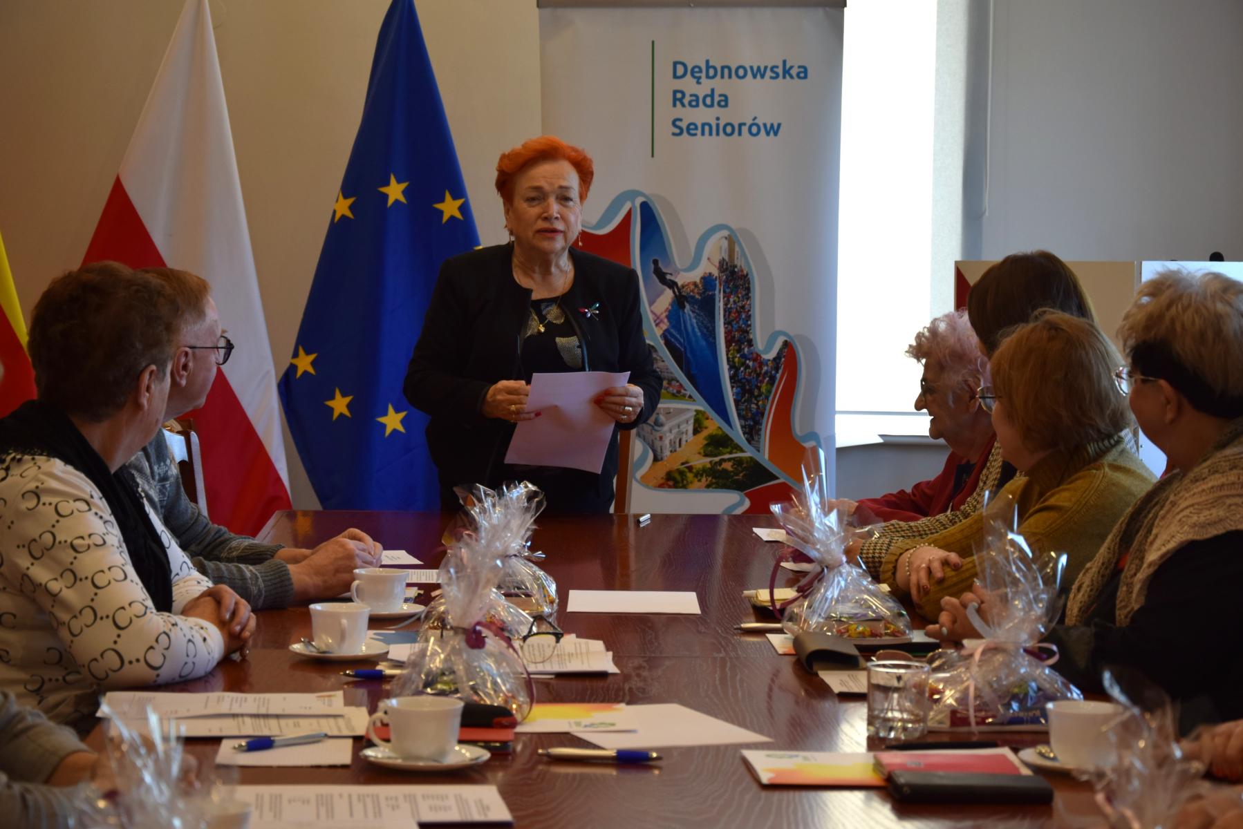 Przewodnicząca DRS stoi w sali, przy stole siedzą radni 