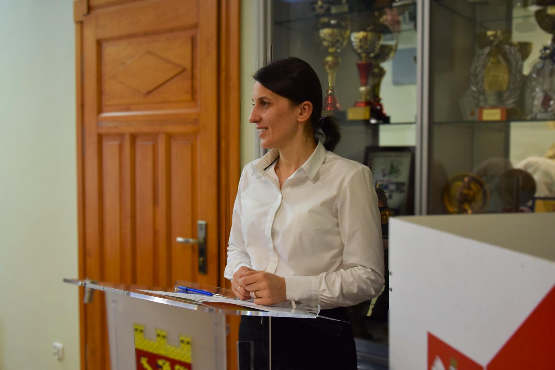 Mariola R&oacute;j, ubrana w białą koszulę stoi przy m&oacute;wnicy 