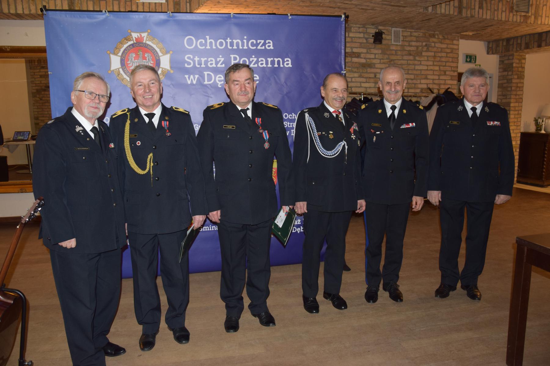 Wyr&oacute;żnione osoby stoją w mundurach