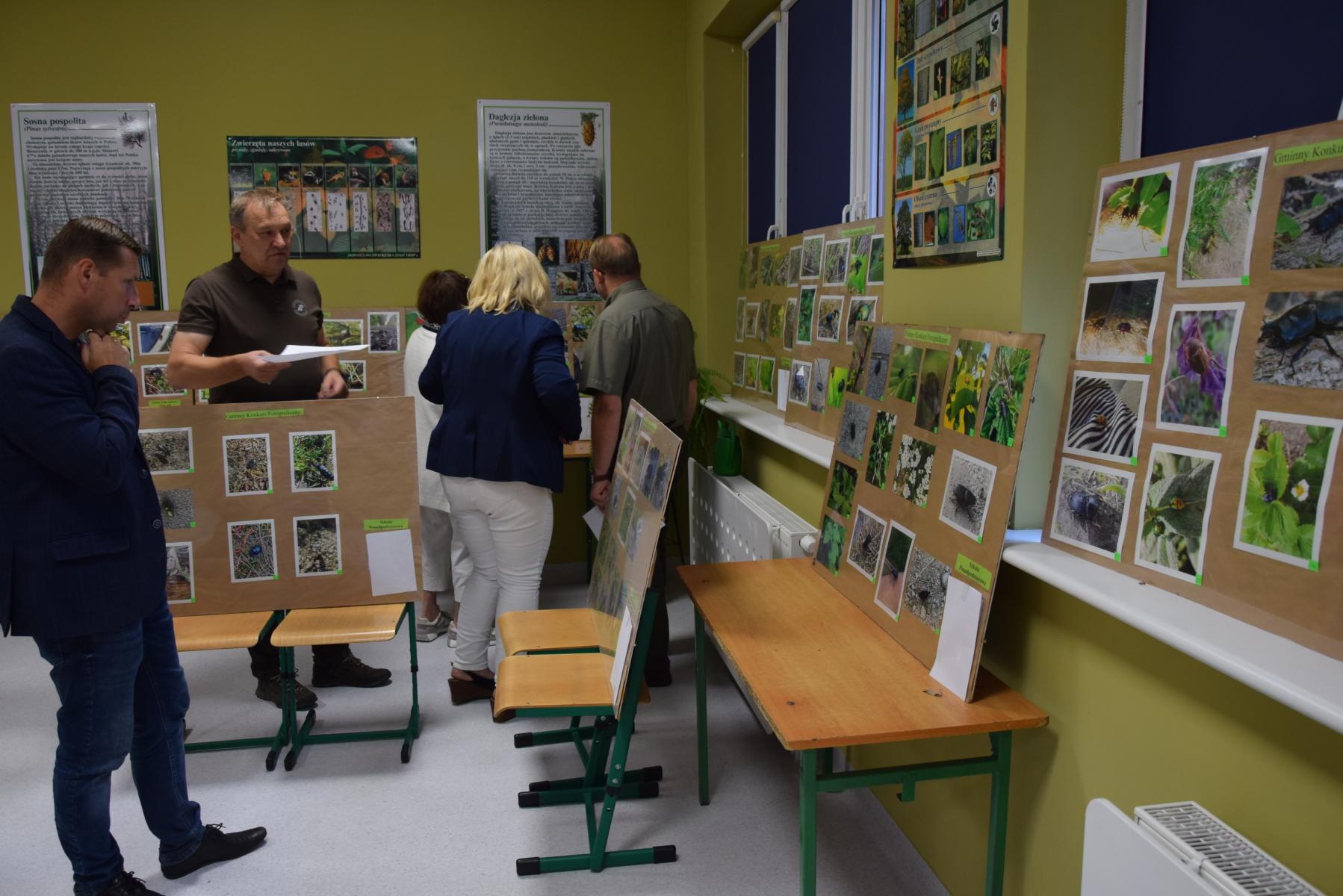 Komisja konkursowa ogląda antyramy, w których są zdjęcia 