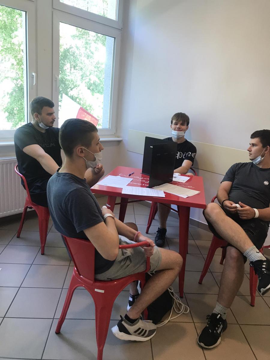 Czterech uczniów siedzi przy stoliku 