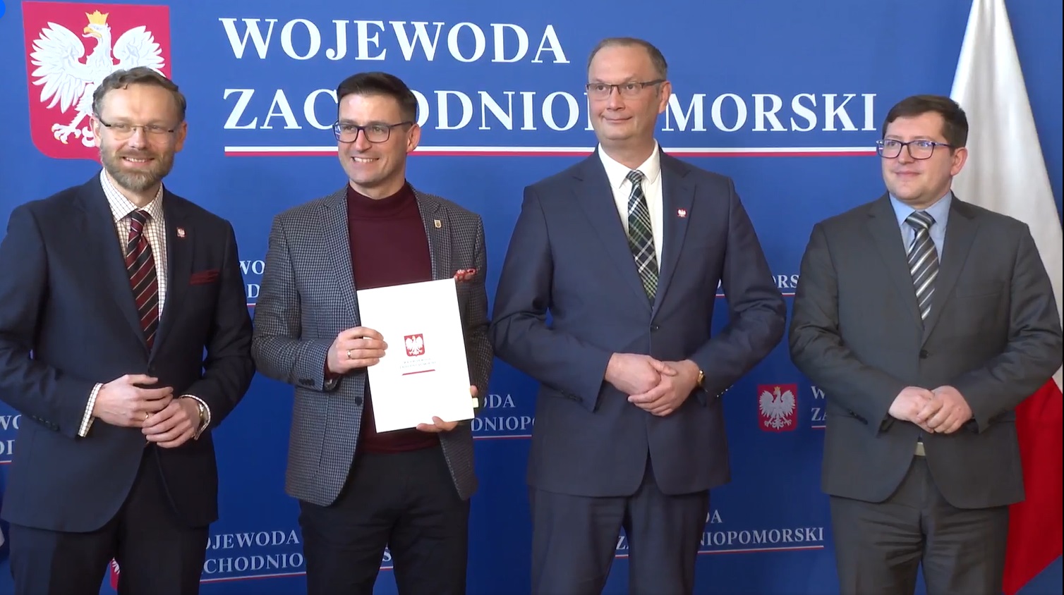 Od lewej stoją: Zbigniew Bogucki, Grzegorz Kulbicki, Tomasza Wójcik i Mateusza Wagemann. W tle niebieska ścianka z godłem i napisem Wojewoda Zachodniopomorski