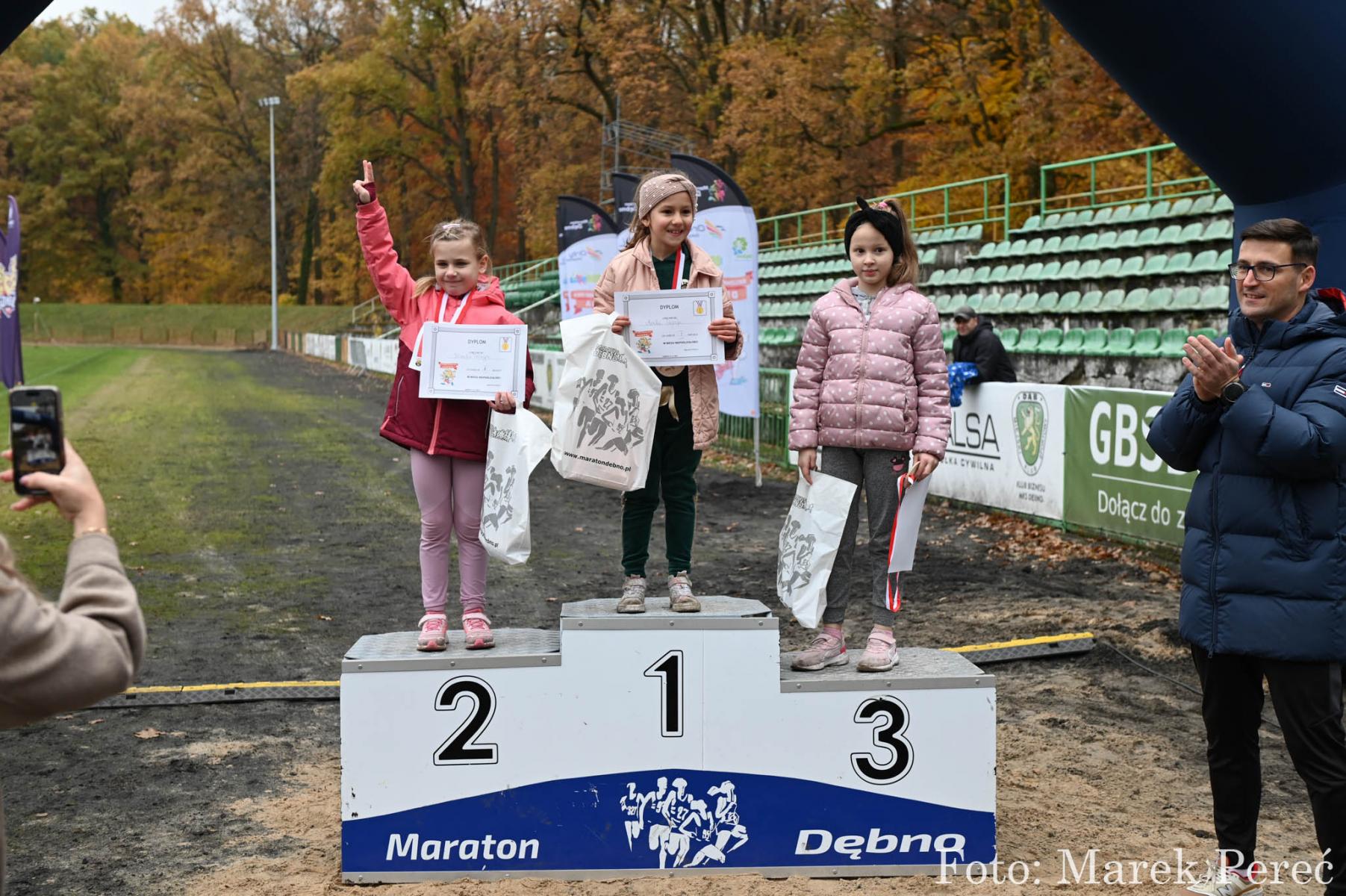 Dziewczynki na podium . W rękach trzymają dyplomy