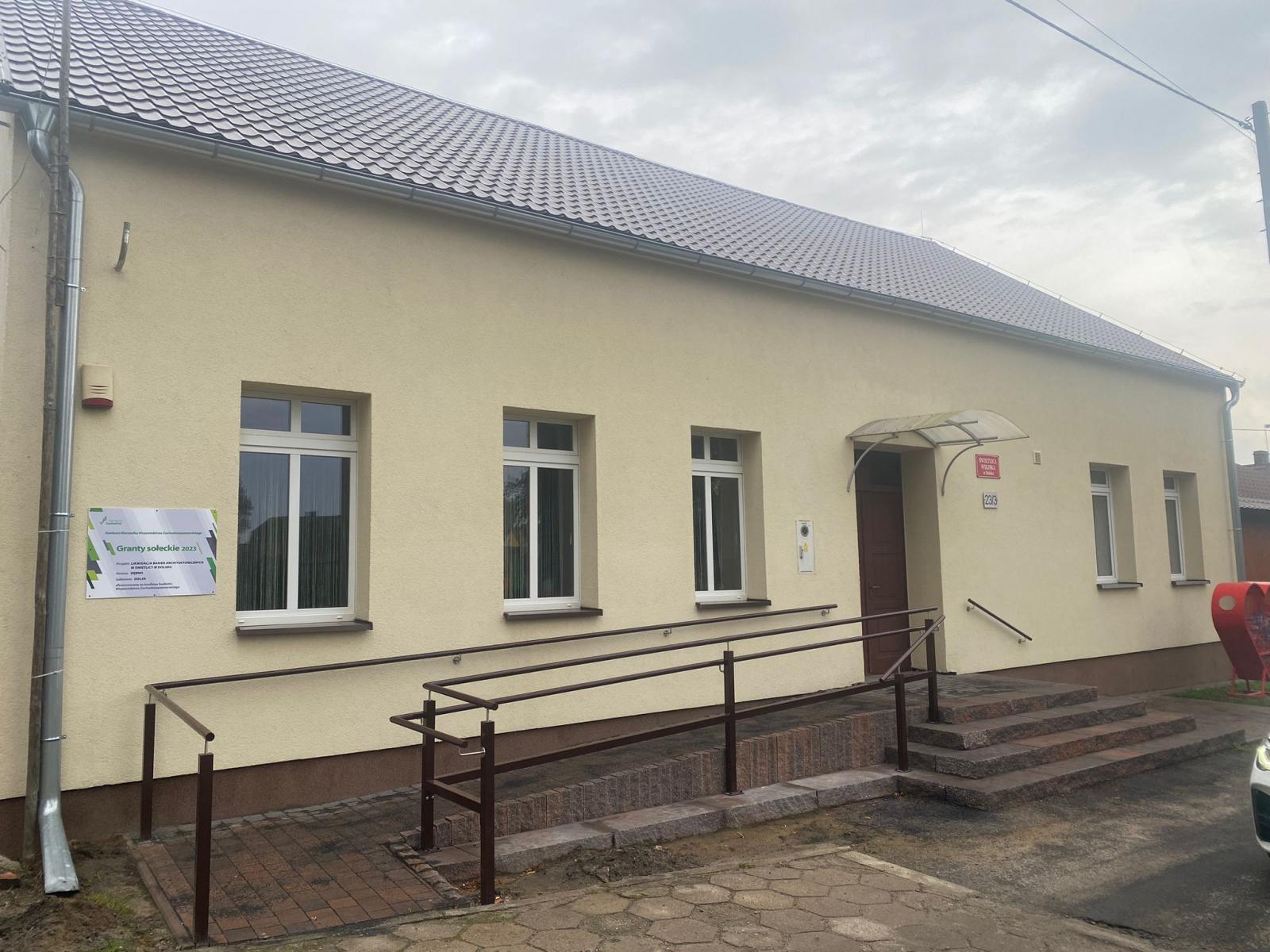 Budynek świetlicy, żółta elewacja schody, poręcz. Daszek nad wejściem 